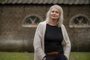 Mirjam staat voor schuur en denkt na