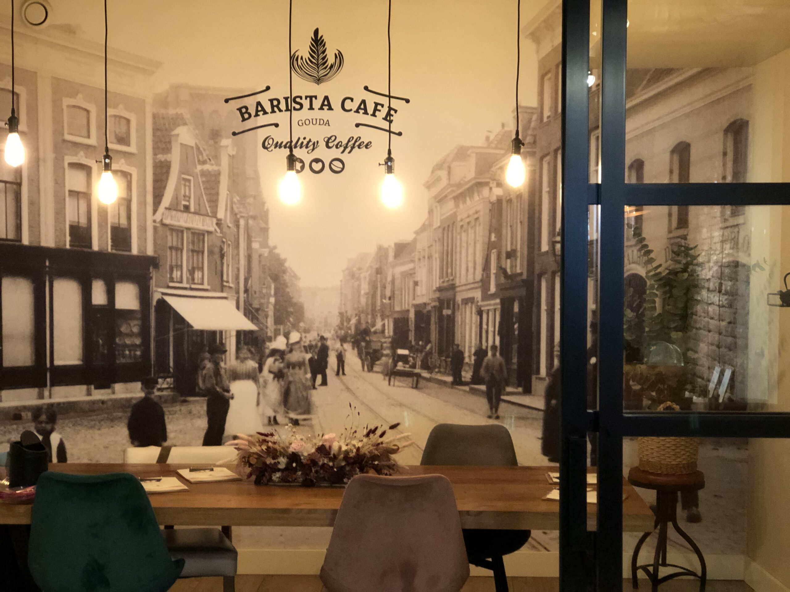 Barista Café Gouda vergaderruimte met loge en straat in Gouda op de muur